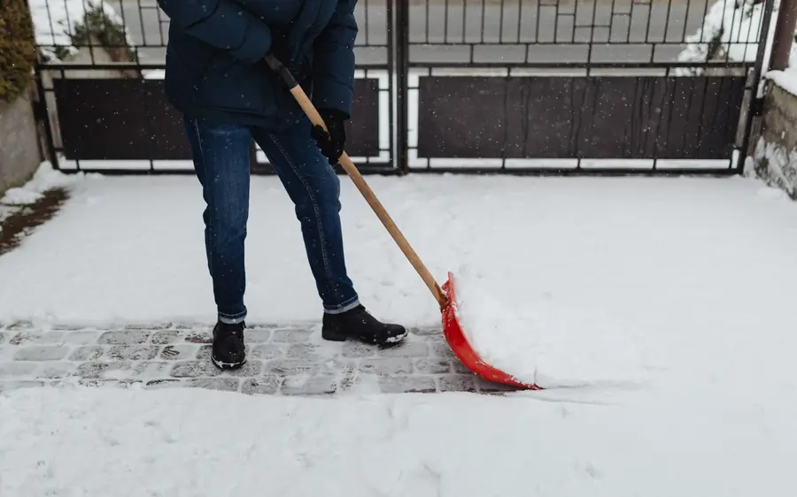 Schneeräumung eines Gehwegs mit Schaufel